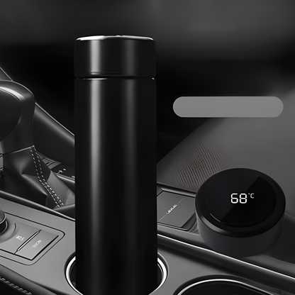 Black thermos bottle on a car dashboard with digital temperature display